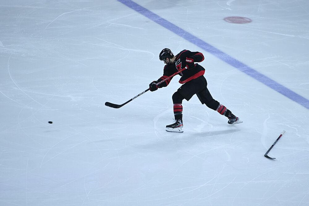 Carolina defenseman Brett Pesce slaps the puck up the ice into the New Jersey zone during the Hurricanes' home game against the New Jersey Devils at PNC Arena on Tuesday, Jan. 10, 2023. The Canes lost to the Devils 5-3.