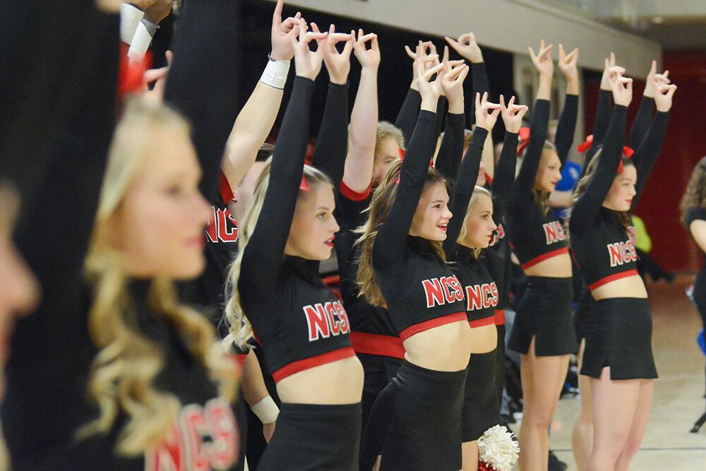 NC State cheerleaders hold up "wolfies" during the gymnastics meet against Pitt and George Washington University at Reynolds Coliseum on Saturday, Jan. 21, 2023. NC State beat Pitt and George Washington with an overall score of 196.650.