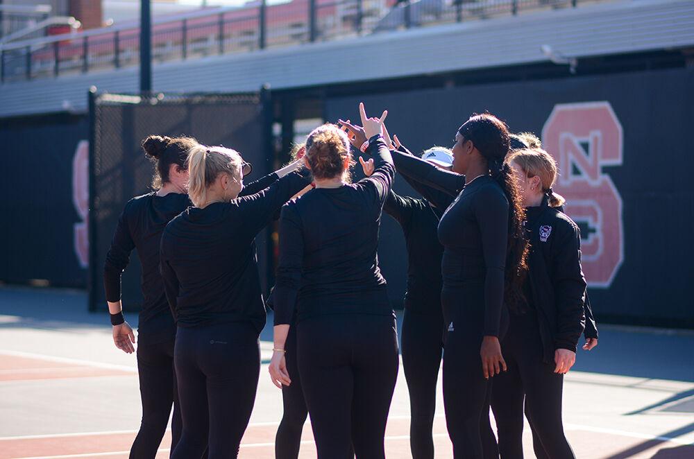 The women's tennis team huddles as they prepare for their match against Illinois at the Dail Outdoor Tennis Stadium on Saturday, Jan. 28, 2023. The Wolfpack won the match 4-0.