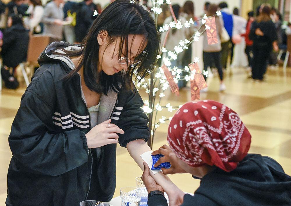 Beiqing Wang, a fourth-year studying biology, gets a temporary tattoo applied during the Lunar New Year celebration on Jan. 25, 2023, in Talley Student Union. Students celebrated the Chinese New Year in an event that included food, activities, and a performance by KPack.
