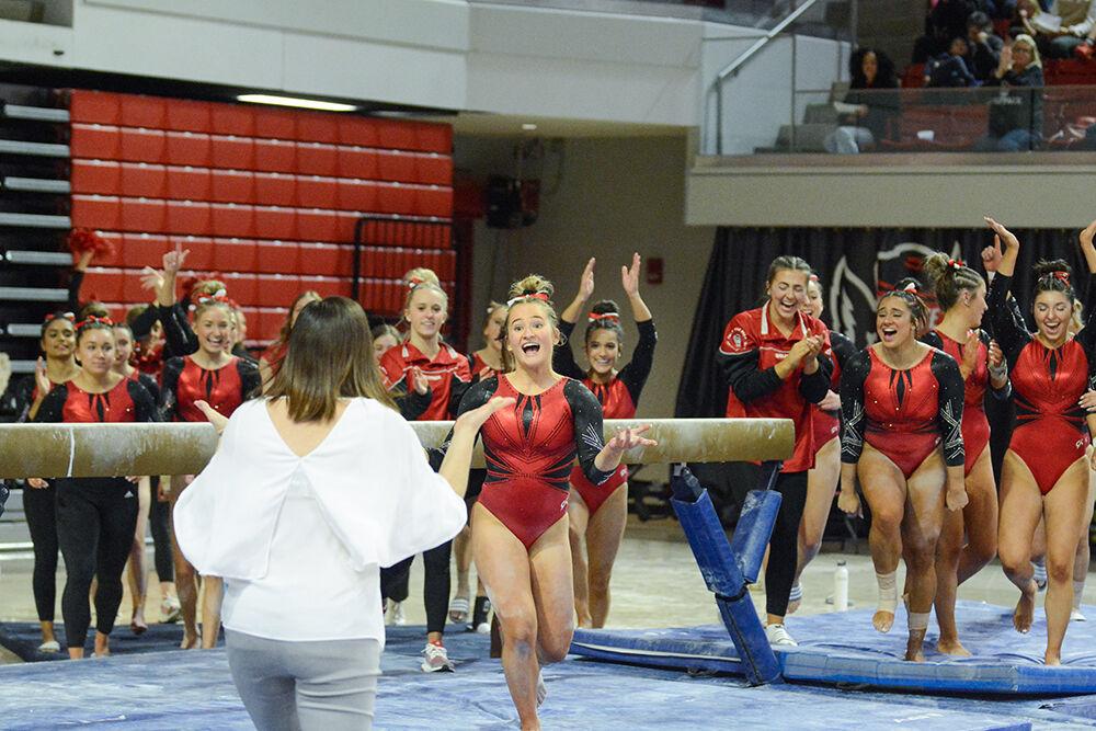 Sophomore gymnast Macy Jennings celebrates with head coach Kim Landrus during the meet against Pitt and George Washington University at Reynolds Coliseum on Saturday, Jan. 21, 2023. Jennings scored a 9.825 on her beam routine. NC State beat Pitt and George Washington with an overall score of 196.650.