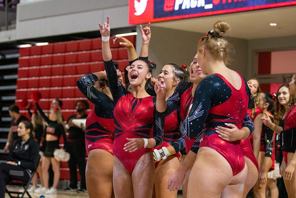 Members of the NC State gymnastics team cheer on their teammates during the meet against Pitt and George Washington at Reynolds Coliseum on Saturday, Jan. 21, 2023. NC State beat Pitt and George Washington with an overall score of 196.650.