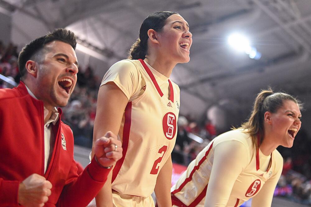 Graduate forward Mimi Collins (center) and graduate center River Baldwin (right) cheer on their teammates during the game against Virginia inside Reynolds Coliseum on Sunday, Jan. 8, 2023. The Wolfpack pulled a win over the Cavaliers 87-62.