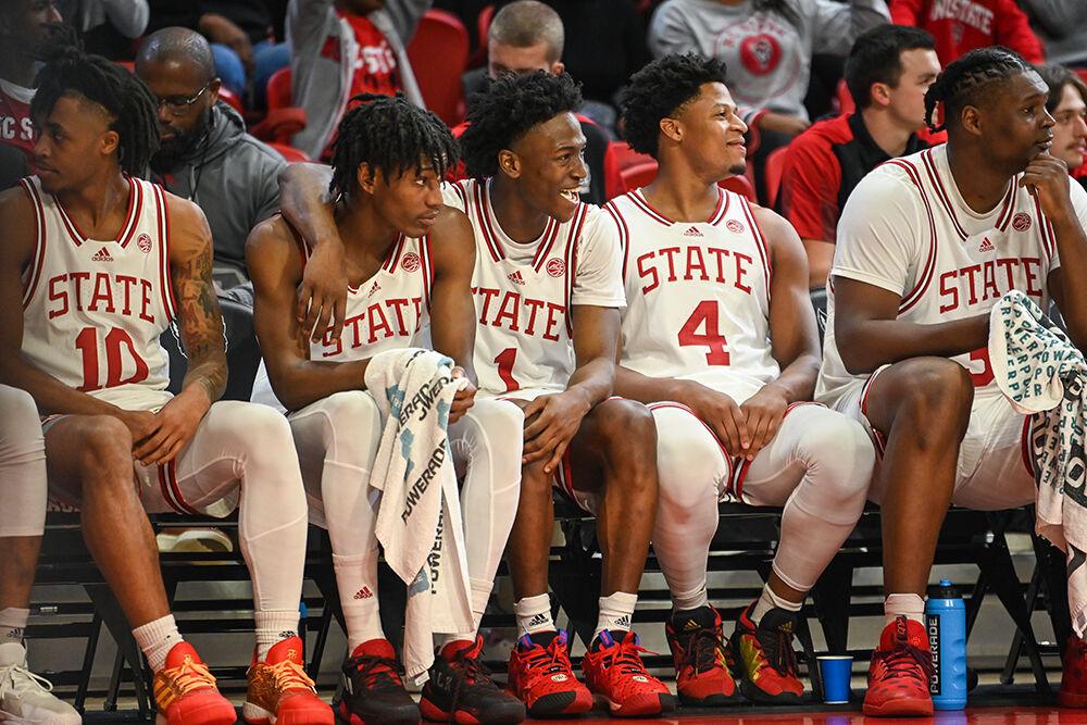 (From left) Sophomore guard Terquavion Smith, graduate guard Jarkel Joiner and freshman guard LJ Thomas smile while looking down the court during the annual Heritage Game against Coppin State in Reynolds Coliseum on Tuesday, Dec. 6, 2022. NC State beat Coppin State 94-72.