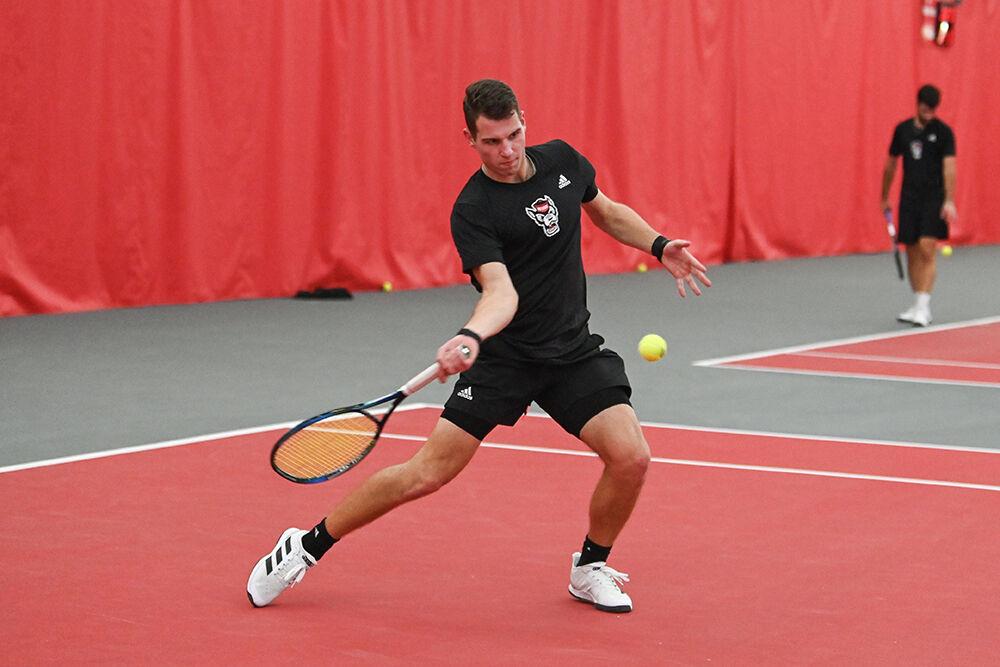 Senior Martins Rocens volleys the ball during his singles match with Harvard player Henry von der Schulenburg at J.W. Isenhour Tennis Center on Friday, Jan. 20, 2023. NC State lost 4-3 to Harvard.