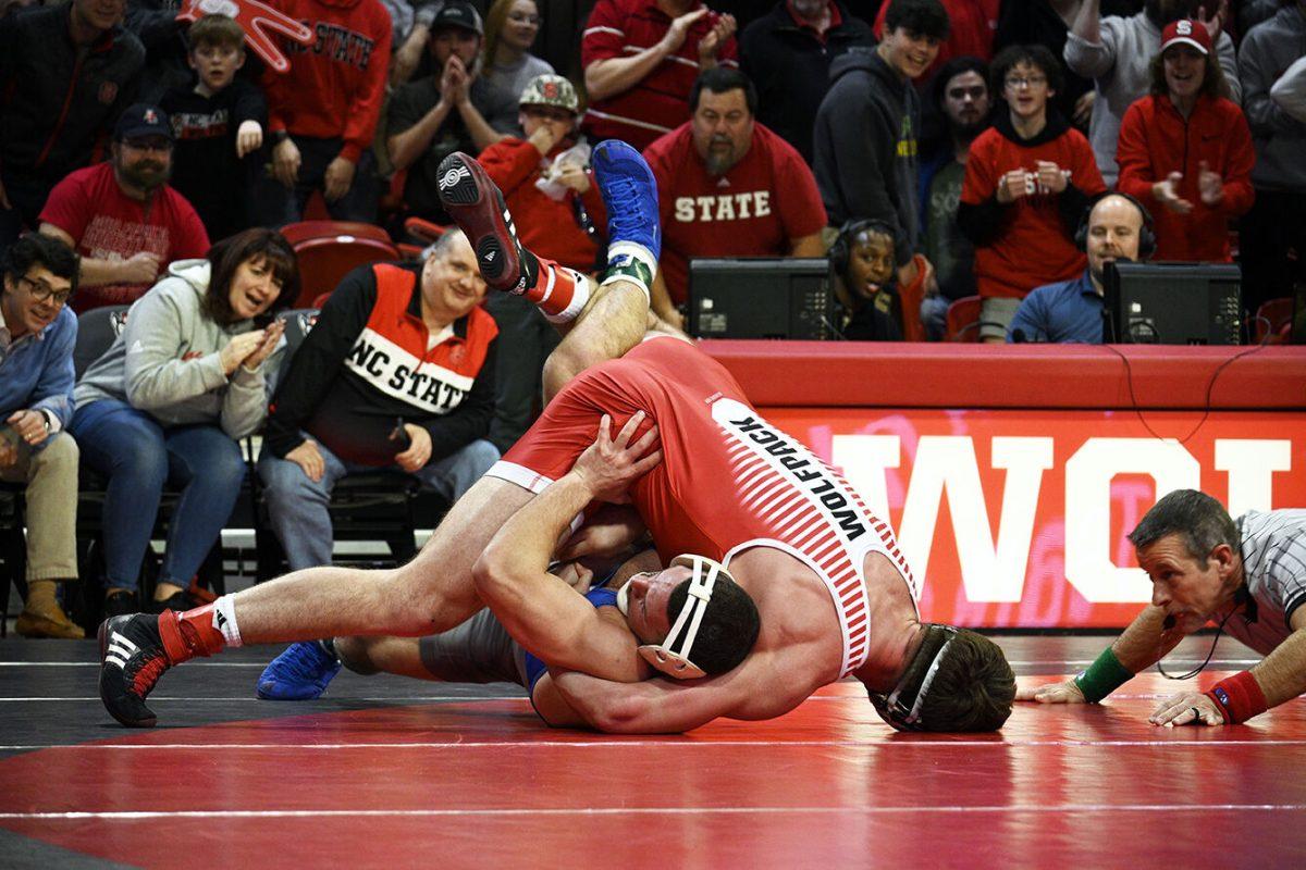 Sophomore Isaac Trumble forces his opponent on the ground during the duel against Duke in Reynolds Coliseum on Friday, Jan. 27, 2023. Trumble won his individual match. NC State beat Duke 46-3.