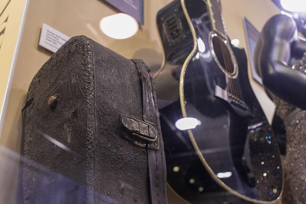 The guitar that Caylee Hammack saved from a house fire, from which the guitar case shows extensive fire damage, on display in The Power of Women in Country Music exhibit at the NC Museum of History on Friday, Feb. 3, 2023.
