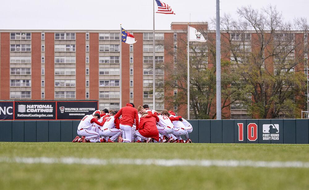 The Wolfpack take a knee together before the game against Quinnipiac on Saturday, Feb. 26, 2022 in Doak Field at Dail Park. The Wolfpack beat the Bobcats 12-10 to win the series.