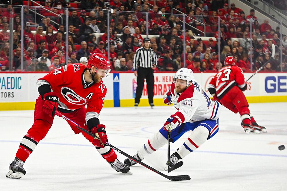 Carolina Hurricanes defenseman Jaccob Slavin hits the puck away from opponent during the game against the Montreal Canadiens in PNC Arena on Thursday, Feb. 16, 2023. The Hurricanes won 6-2.