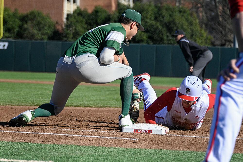Graduate outfielder Parker Nolan slides back to first base during the game against Wagner at Doak Field in Dail Park on Saturday, Feb 18, 2023. NC State beat Wagner 3-2 to win the series.