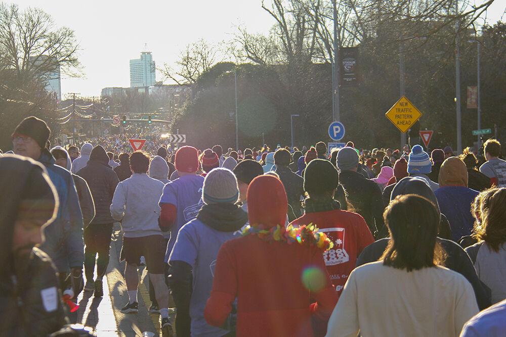Runners race down the street during the Krispy Kreme Challenge on Hillborough Street on Feb. 4, 2023. The challenge is an annual charity event where participants attempt to run five miles and eat a dozen donuts at the midpoint of the race, all within an hour.