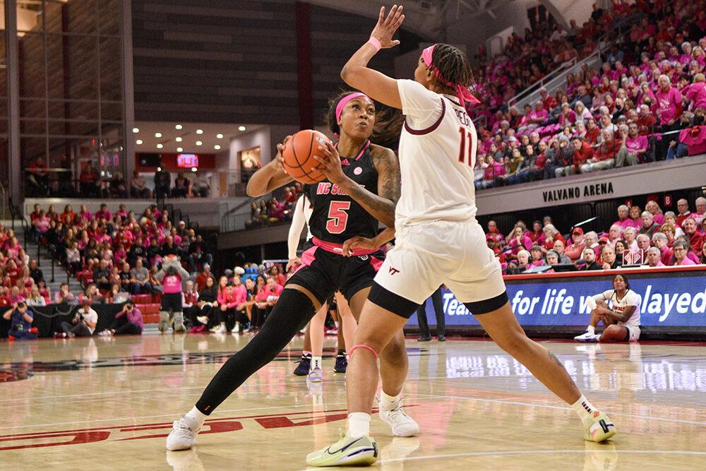 Senior forward Jada Boyd passes the ball away from defenders during the game against Virginia Tech at William Neal Reynolds Coliseum on Mon. Feb. 6, 2023. The Play4Kay event was held during the game as a memorial to former head coach Kay Yow and a celebration for all who have suffered from breast cancer. Virginia Tech won 73-61.