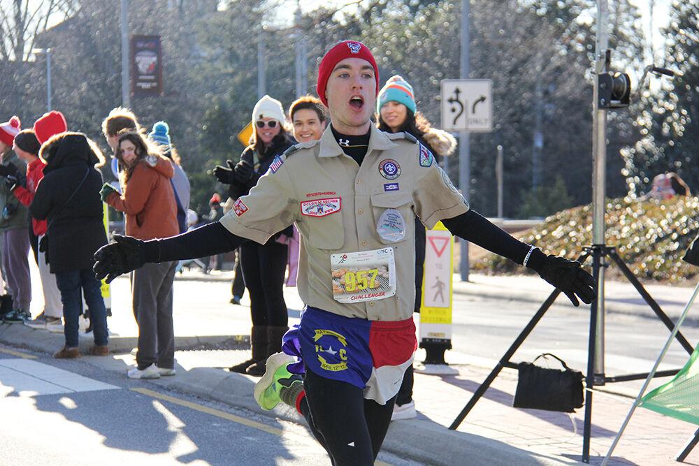 Jesse Carr celebrates after completing the Krispy Kreme Challenge on Hillsborough Street on Feb. 4, 2023. The challenge is an annual charity event where participants attempt to run five miles and eat a dozen donuts at the midpoint of the race, all within an hour. Carr was the third challenger to finish, with a chip time of 34:08 minutes.
