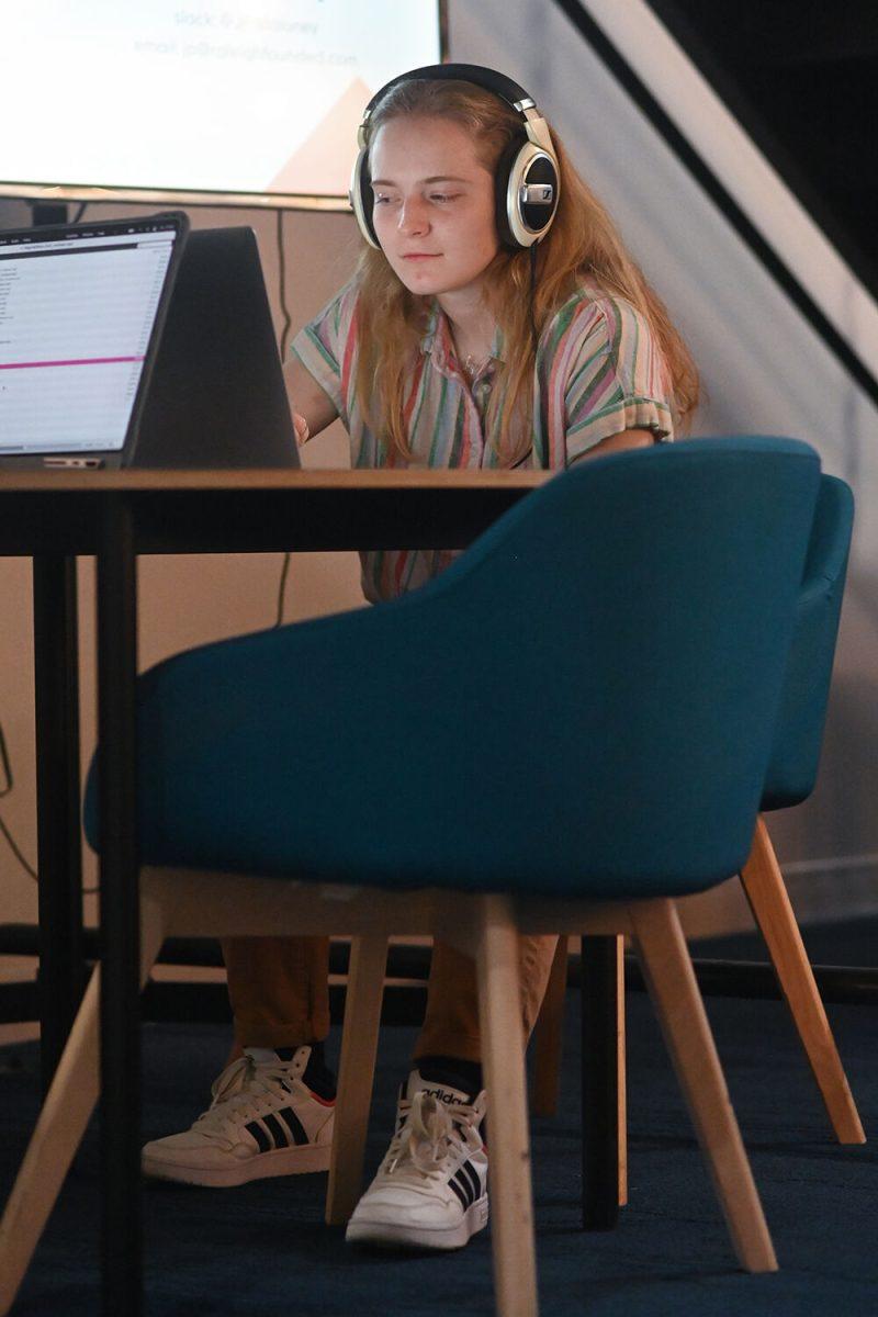 Lauren Elvington, a first-year studying biological and agricultural engineering technologies, listens to NC State's stories at the Nomadic Photo Ark popup exhibit at the Partners Building one on Friday, Feb 10, 2023. The Nomadic Photo Ark popup exhibit featured qoutes and photos of individuals on NC State campus.