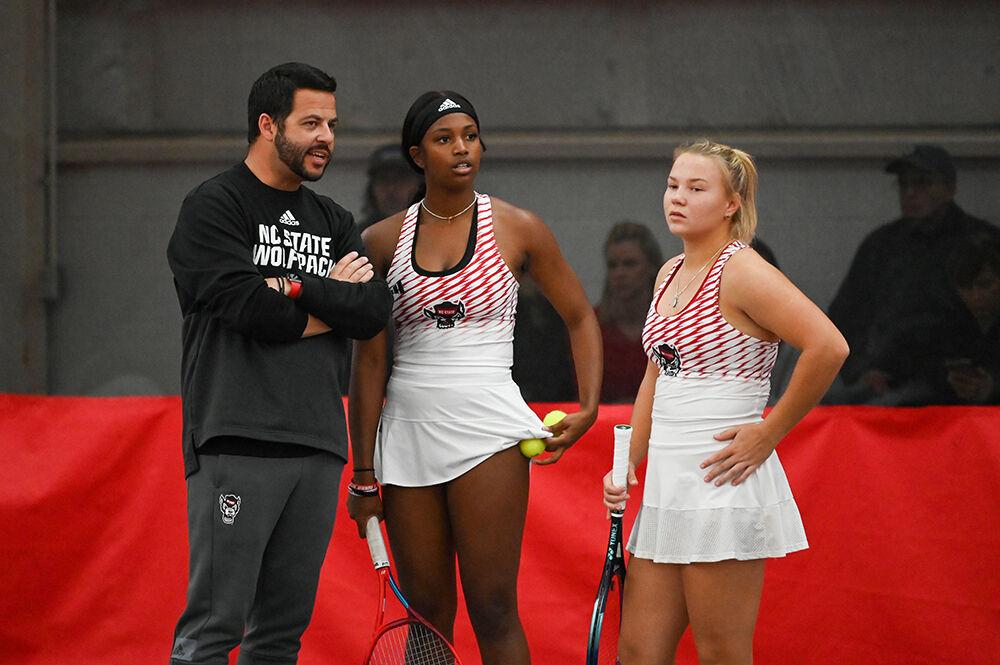 Assistant coach David Secker (left) advises graduate student Alana Smith (middle) and freshman Diana Shnaider during the match against Tennessee at J.W. Isenhour Tennis Center on Sunday, Feb. 5, 2023. NC State beat Tennessee 6-1.