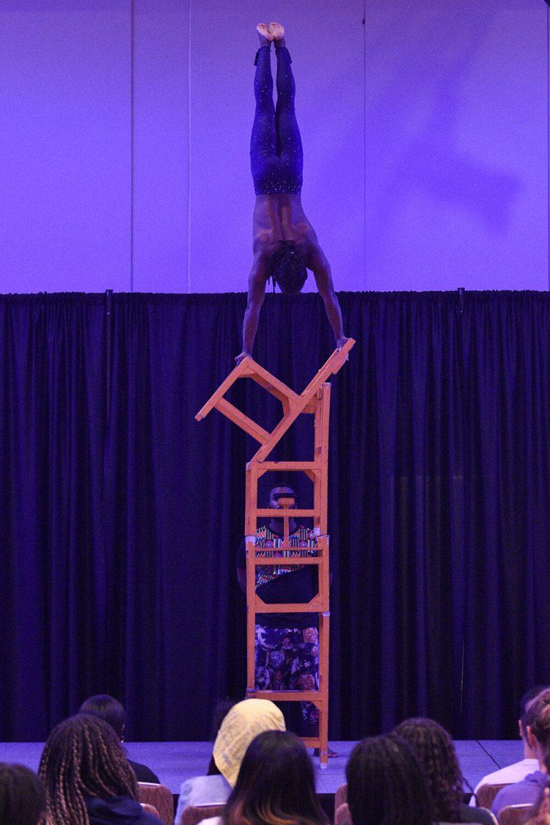 An acrobat does a handstand on a tower of chairs in the Piedmont-Mountain Ballroom in Talley Student Union on Wednesday, Feb. 8, 2023. The Zuzu Acrobats performance was organized by the Black Students Board.