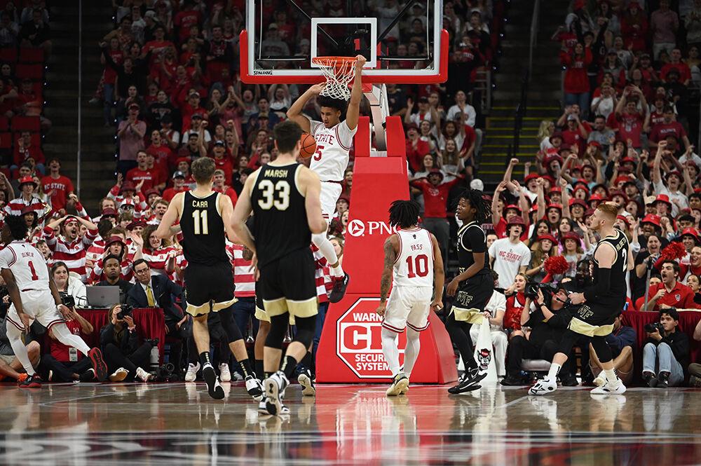 Graduate guard Jack Clark hangs on the rim for a dunk during the Wolfpack's home game against the Wake Forest Demon Deacons in PNC Arena on Wednesday, Feb. 22, 2023. The Wolfpack beat the Demon Deacons 90-74.