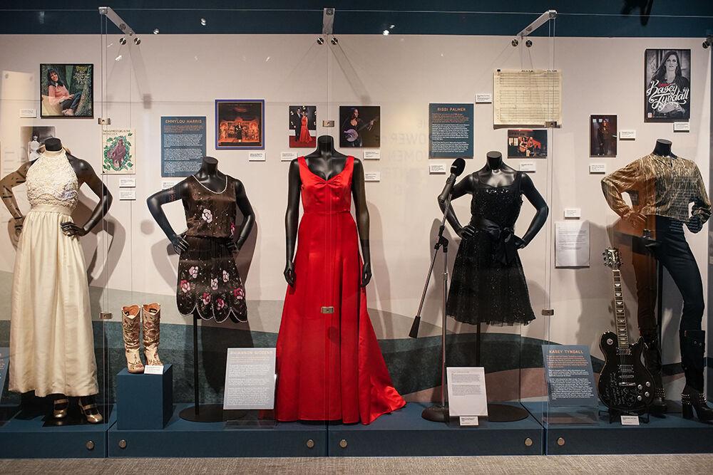 A variety of memorabilia on display featuring North Carolina-related artists on display in The Power of Women in Country Music exhibit at the NC Museum of History on Friday, Feb. 3, 2023. The attention-grabbing red dress in the center of the display was worn by Rhiannon Giddens of the Carolina Chocolate Drops at the Grammy Awards in 2020.