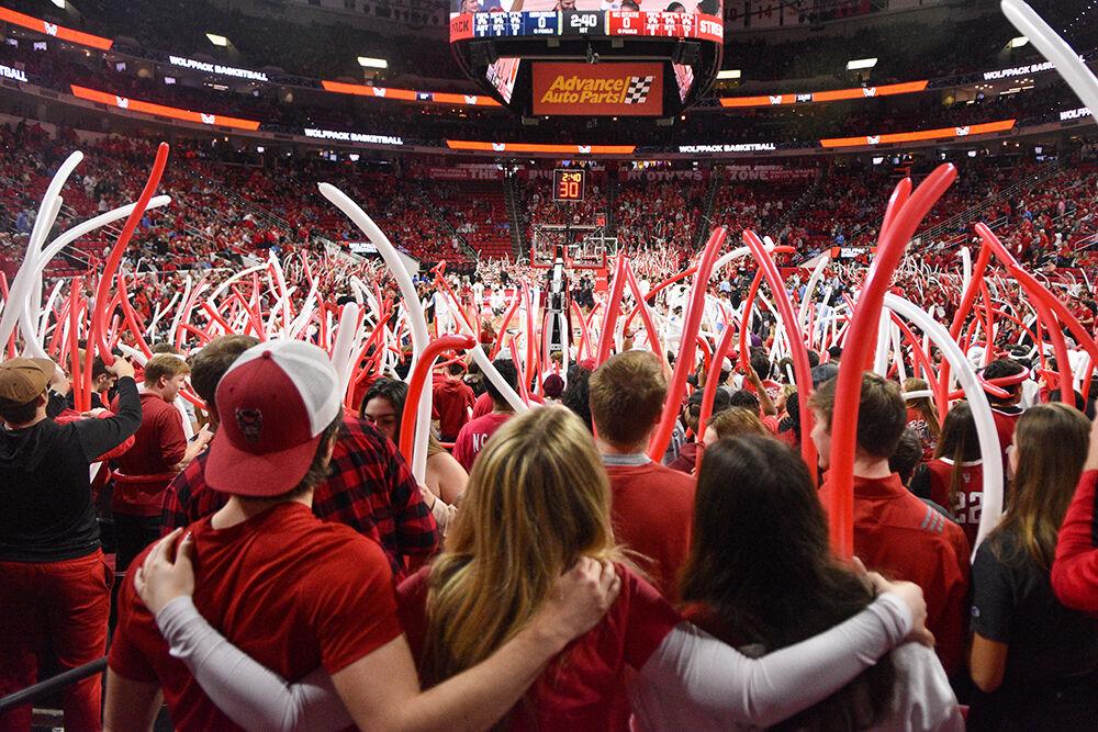 NC State fans hold each other during the national anthem before the game against UNC-Chapel Hill in PNC Arena on Sunday, Feb. 19, 2023. The Wolfpack beat the Tar Heels 77-69.