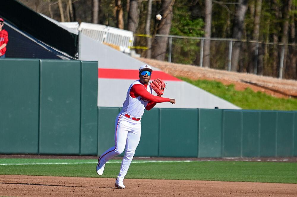 Junior infielder LuJames Groover III passes the ball to his teammates during the game against Wagner at Doak Field in Dail Park on Saturday, Feb. 18, 2023. Saturday was the second game in the Wolfpack versus Wagner series. NC State beat Wagner 3-2 to win the series.