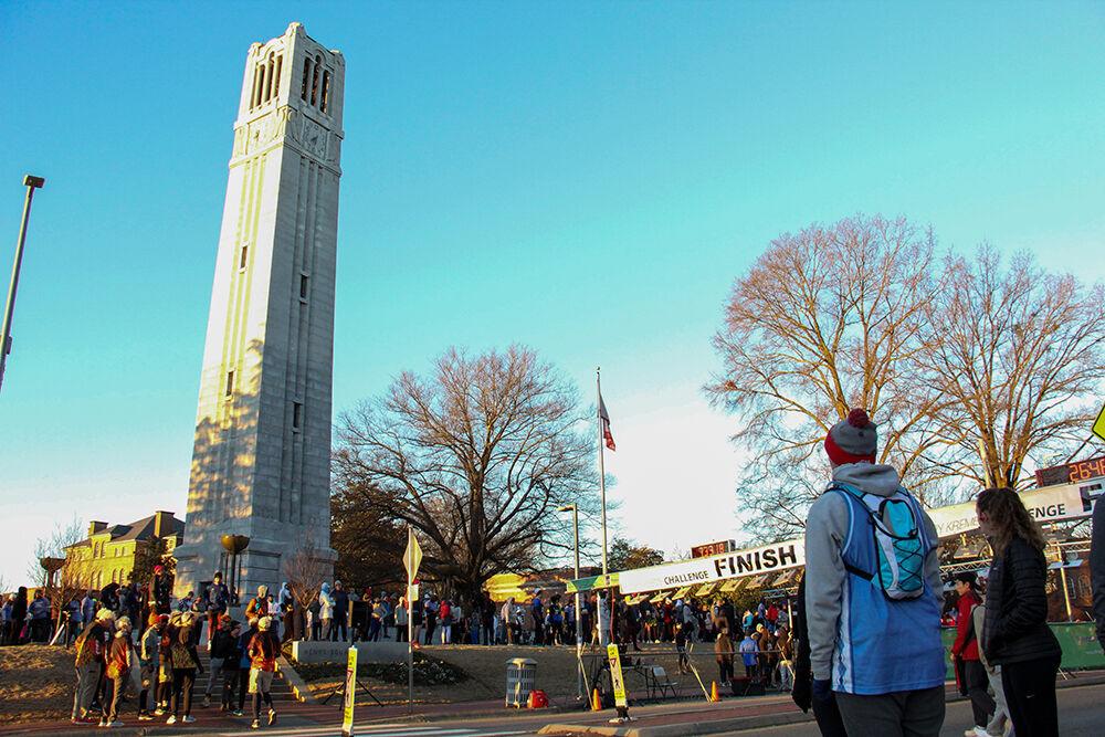 A crowd gathers around the NC State Memorial Belltower before the Krispy Kreme Challenge on Hillsborough Street on Feb. 4, 2023. The challenge is an annual charity event where participants attempt to run five miles and eat a dozen donuts at the midpoint of the race, all within an hour.
