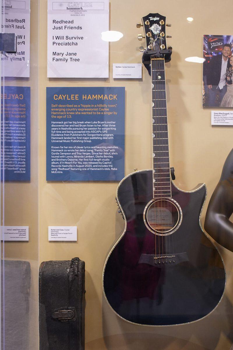The guitar that Caylee Hammack saved from a house fire, from which the guitar case shows extensive fire damage, on display in The Power of Women in Country Music exhibit at the NC Museum of History on Friday, Feb. 3, 2023.