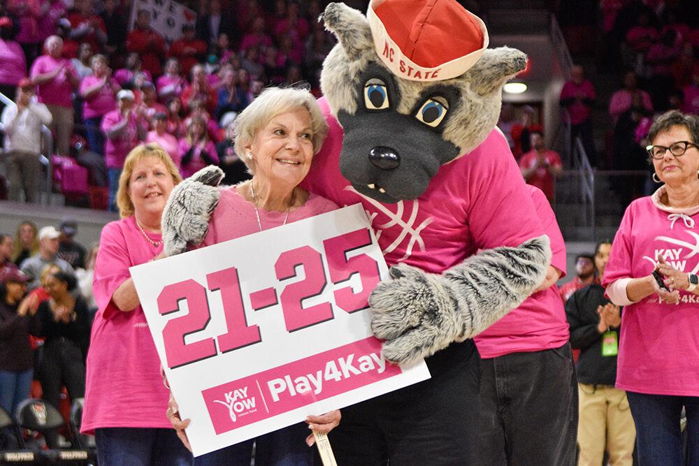 Lee Radford (left) hugs Tuffy during the halftime celebration of cancer surviors in the game against Virginia Tech at William Neal Reynolds Coliseum on Mon. Feb. 6, 2023. Radford was the line leader for women that have fought cancer for 21-25 years. The Play4Kay event was held during the game as a memorial to former head coach Kay Yow and a celebration for all who have suffered from breast cancer. Virginia Tech won 73-61.
