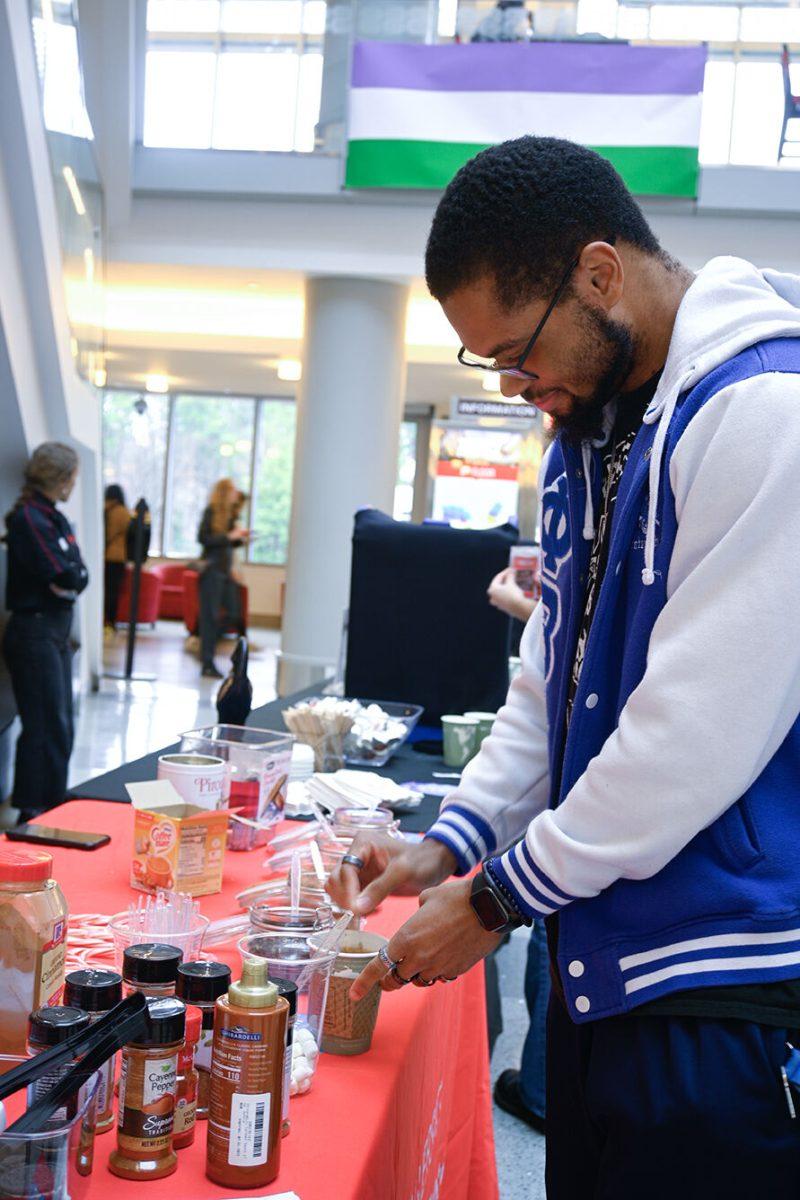 Adonis Belton, a fourth-year studying psychology, grabs a cup of hot chocolate at the Black History Month Kickoff in Talley Student Union on Feb. 1, 2023. The theme for this year's black history month is Black Euphoria.