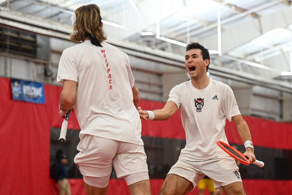 (From left) Senior Robin Catry and junior Luca Staeheli celebrate scoring a point during their doubles match against Michigan at J.W. Isenhour Tennis Center on Friday, Feb. 10, 2023. The doubles match went unfinished. NC State lost 4-0 to Michigan.