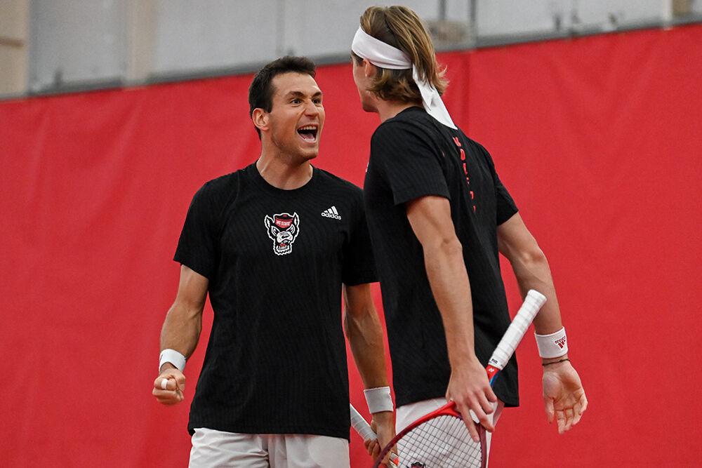 Junior Luca Staeheli (left) and senior Robin Catry yell in celebration as they prepare to chest bump after winning their doubles match against Miami at J.W. Isenhour Tennis Center on Friday, March 10, 2023. Staeheli and Catry won their doubles match 6-3. NC State beat Miami 4-2.