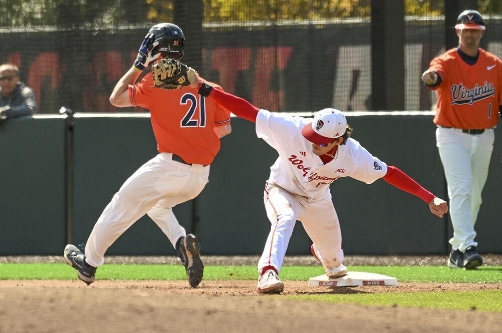 Freshman infielder Eli Serrano tags a runner out at first base during the game against the University of Virginia at Doak Field at Dail Park on Saturday, March 18, 2023. NC State beat UVA 5-4.
