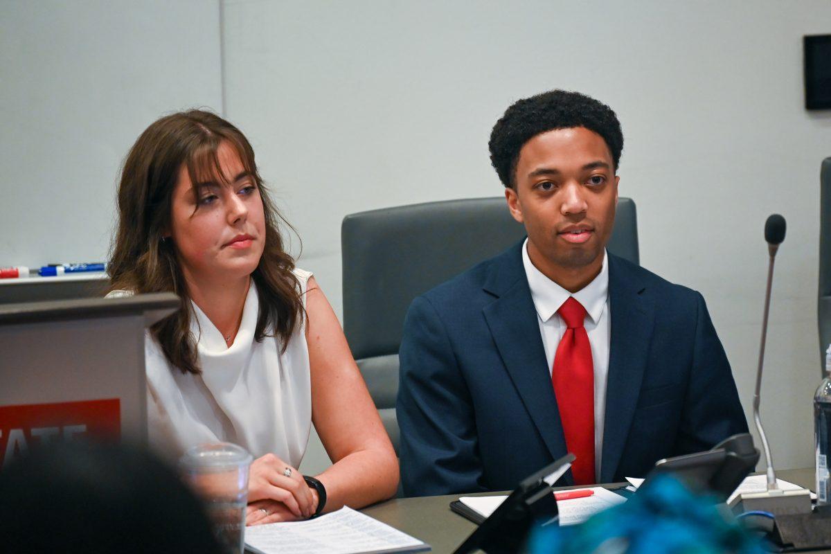 Timothy Reid, a third-year studying business administration and Allison Markert, a second-year studying natural resources listen to a question during the debate hosted by Technician and Nubian Message in Talley Student Union on Friday, March 3, 2023.