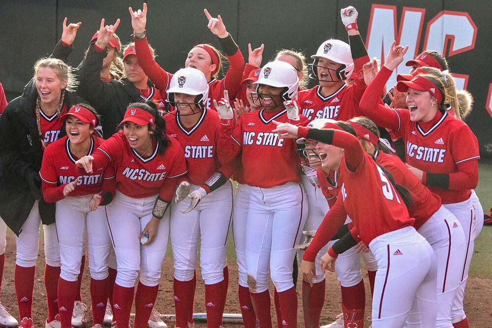 Members of the NC State softball team cheer on one of their players as they run to home base during the game against North Carolina Central University at Dail Softball Stadium on Wednesday, March 8, 2023. NC State beat NCCU 19-9.