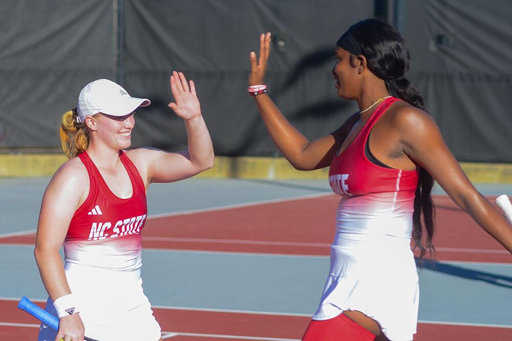 Junior Sophie Abrams (left) and graduate student Alana Smith (right) high-five during their doubles match against East Tennessee State at the Dail Outdoor Tennis Stadium on Sunday, March 5, 2023. Abrams and Smith won their doubles match 6-1. NC State beat ETSU 7-0.