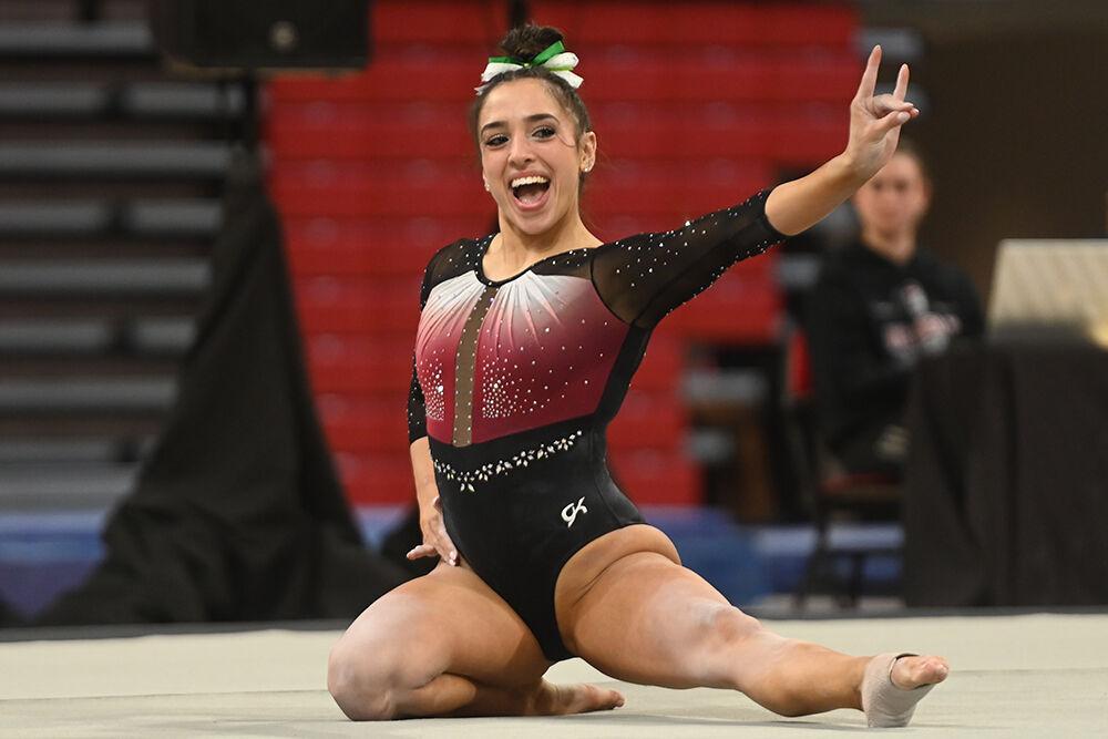 Junior Gabrielle Diaz poses while holding up a "wolfie" during her floor routine at the meet against New Hampshire in Reynolds Coliseum on Friday, Feb. 17, 2023. Diaz scored a 9.850 for the event. NC State beat New Hampshire with a final score of 196.150.
