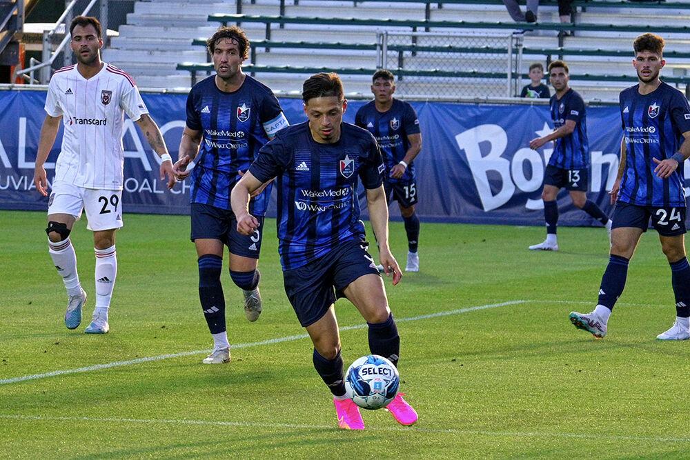 North Carolina FC defender Nelson Flores Blanco dribbles the ball away from his opponent during the game against the Chattanooga Red Wolves at&#160;Sahlen's Stadium in WakeMed Soccer Park on Friday, April 21, 2023. NCFC beat the Chattanooga Red Wolves 3-0.