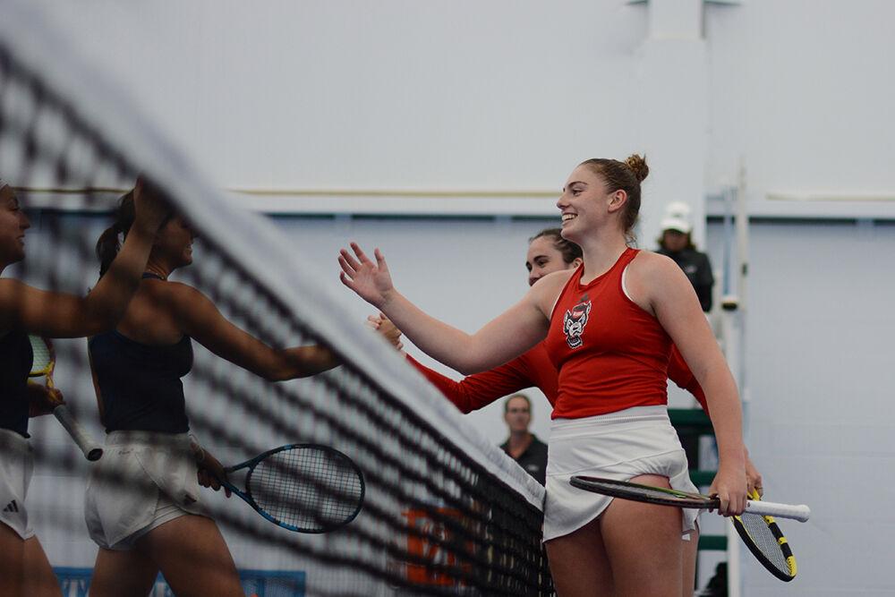 Junior Amelia Rajecki smiles as she and her doubles partner graduate Nell Miller shake hands with their opponents after the&#160;2023 ACC Women's Tennis Championship match&#160;against Georgia Tech in the Cone-Kenfield Tennis Center on Saturday, April 22, 2023. The pair won their doubles match 6-4. The Wolfpack defeated the Yellow Jackets 5-0.