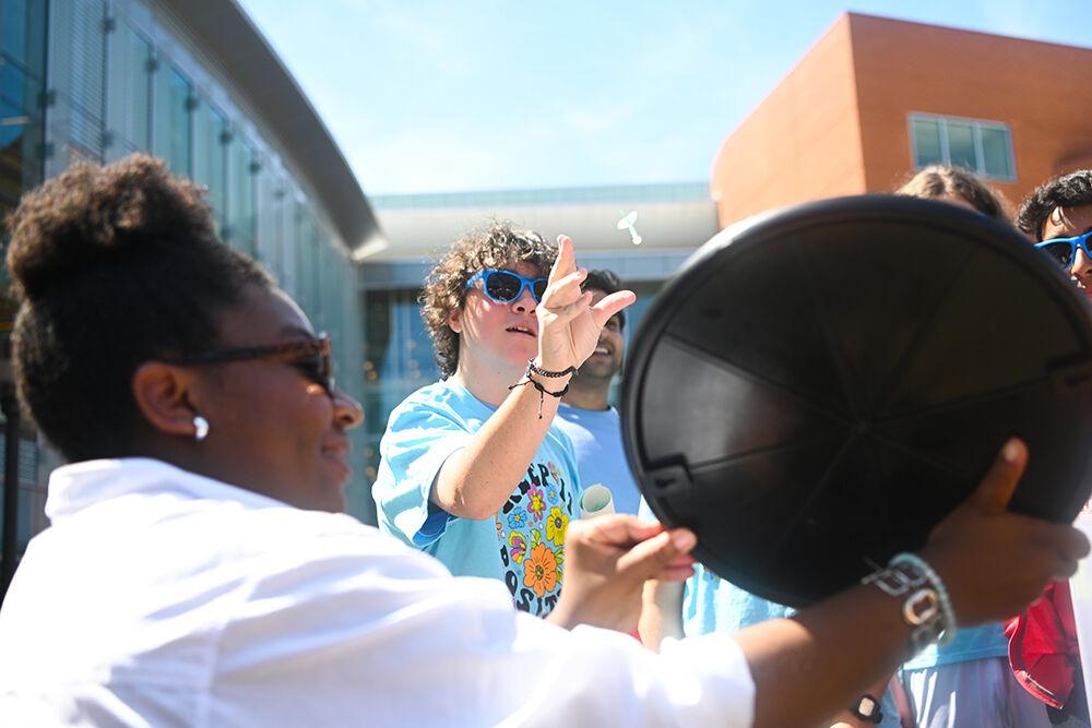 Miguel Gaspar, a Wake STEM Early College student, participates in a game of darts with Rachel Haynes, the program manager for the Business Sustainability Collaborative, at the Earth Fair on Stafford Commons on Wednesday, April 12, 2023. The Earth Fair was an annual event that promotes sustainability in a multitude of facets such as food, water, transportation, wellness and more.
