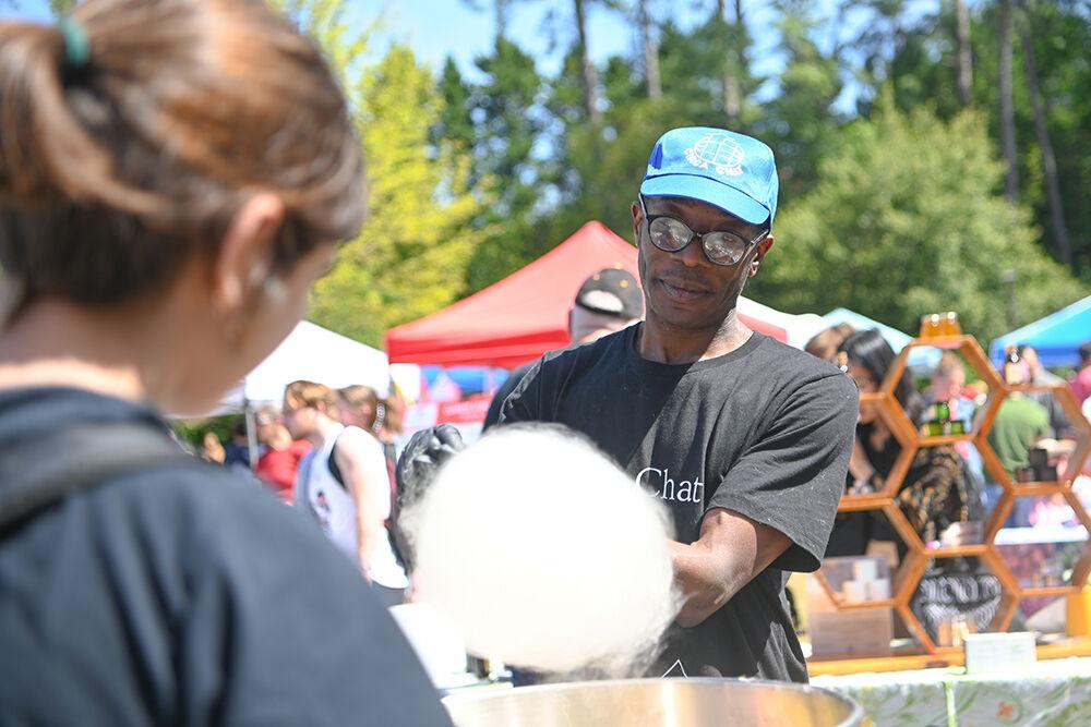 Latir Ndure, a representative of CircaChat, makes a student cotton candy by utilizing solar power at the Earth Fair on Stafford Commons on Wednesday, April 12, 2023. The Earth Fair was an annual event that promoted sustainability in a multitude of facets such as food, water, transportation, wellness and more.