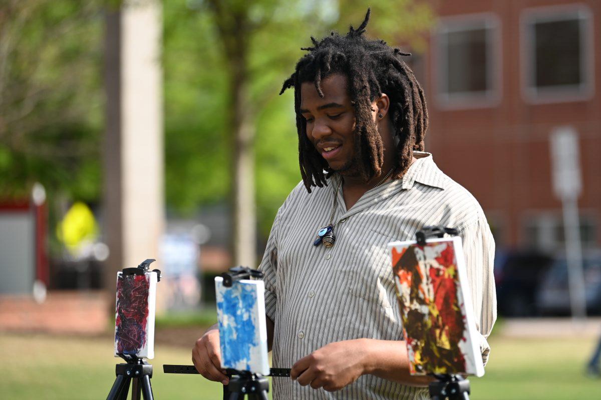 Julian Doaks, a fourth-year studying philosophy, sets up his artwork at the Black Artist Coalition&#8217;s April Showcase at Harris Field on Thursday, April 6, 2023. The showcase included performances from local artists and art sales, and it was one of the events held during the Pan-Afrikan week.