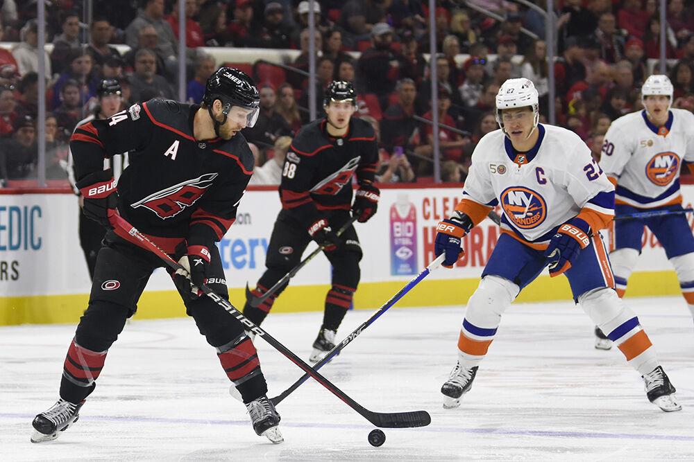 Carolina Hurricanes defenseman Jaccob Slavin dribbles the ice puck away from an opponent during the game against the New York Islanders in PNC Arena on Sunday, April 2, 2023. The Hurricanes won 2-1.