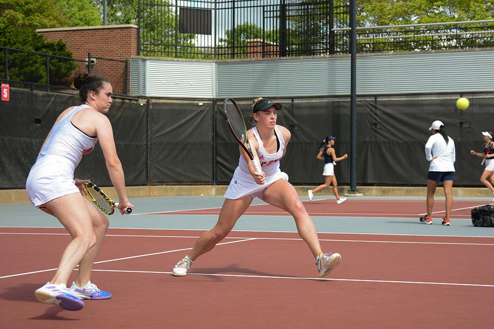 Senior Nell Miller (left) watches her doubles partner junior Amelia Rajecki reach for the ball during the match against Virginia at the Dail Outdoor Tennis Stadium on Friday, April 14, 2023. The pair won their doubles match 6-3. The Wolfpack beat the Cavaliers 5-2.