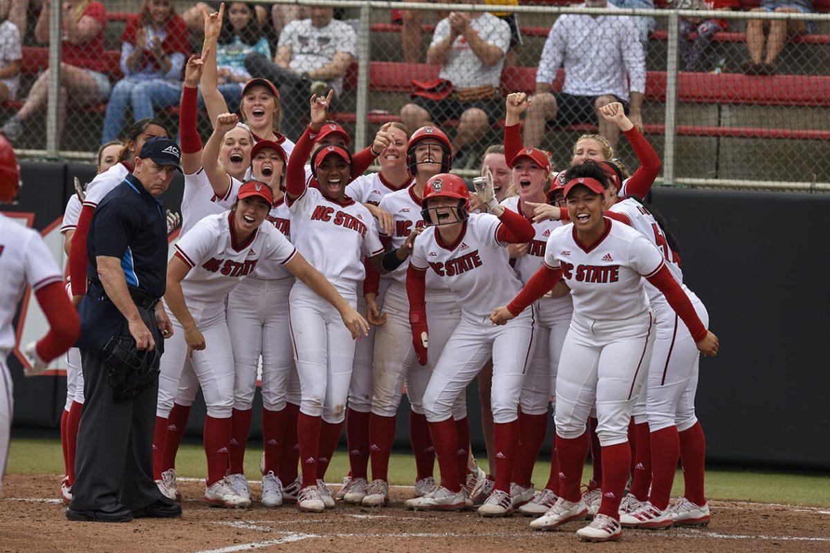 Members of the NC State softball team cheer on their teammates as they score a run during the game against Clemson at Dail Softball Stadium on Sunday, April 16, 2023. NC State beat Clemson 7-5.