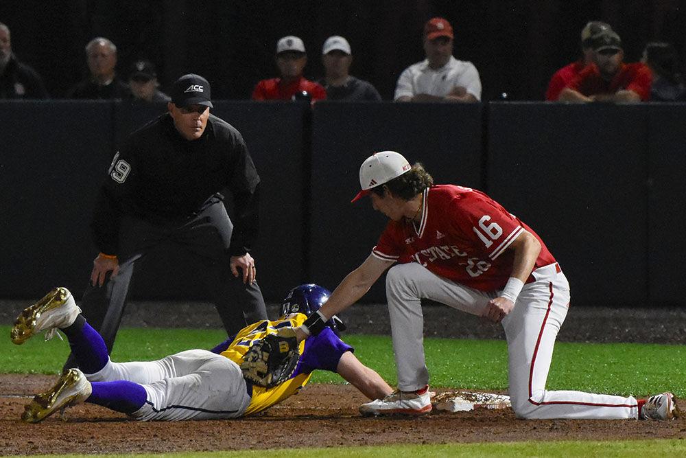 Freshman infielder/outfielder Eli Serrano attempts to tag out an East Carolina University player at first base during the game against ECU at Doak Field at Dail Park on Tuesday, April 25, 2023. NC State beat ECU 5-4.
