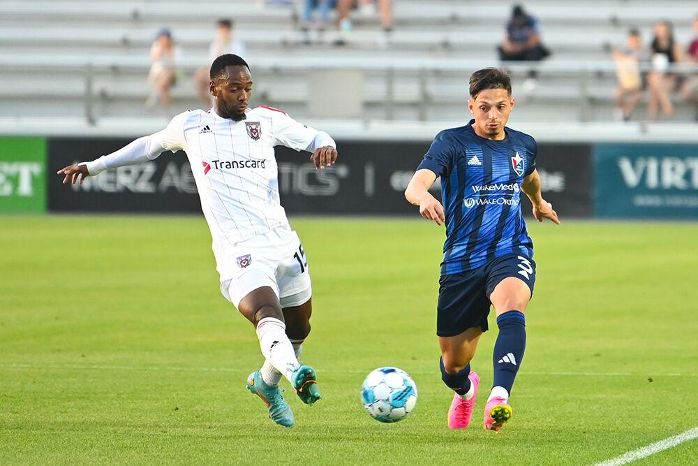North Carolina FC defender Nelson Flores Blanco attempts to steal the ball from a Chattanooga Red Wolves opponent at Sahlen's Stadium in WakeMed Soccer Park on Friday, April 21, 2023. NCFC beat the Red Wolves 3-0.