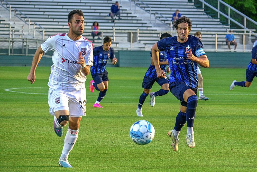 North Carolina FC defender Daniel Navarro races his opponent to the ball during the game against the Chattanooga Red Wolves at Sahlen's Stadium in WakeMed Soccer Park on Friday, April 21, 2023. NCFC beat the Chattanooga Red Wolves 3-0.