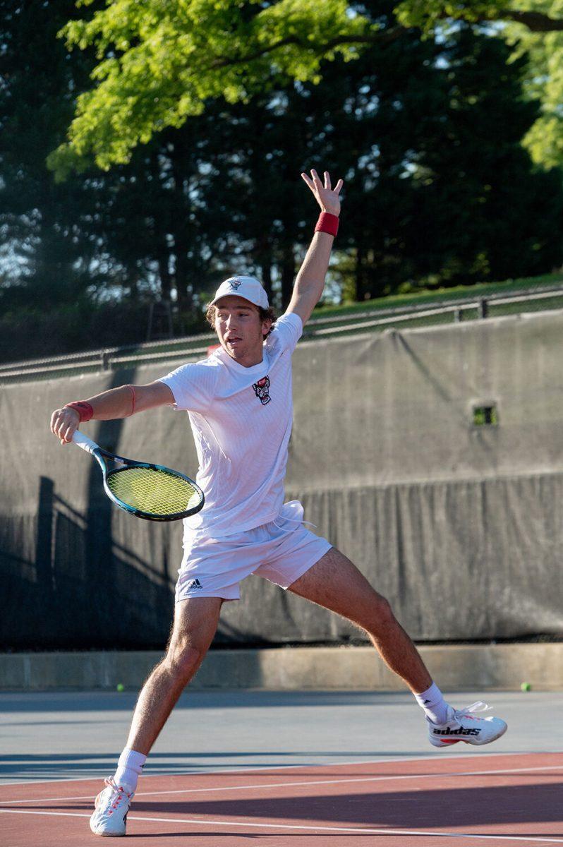Sophomore Joseph Wayand backhands the ball during the match against Wake Forest at Dail Outdoor Tennis Stadium on Wednesday, April 12, 2023. Wayand won both his singles and doubles matches. NC State beat Wake Forest 4-2.