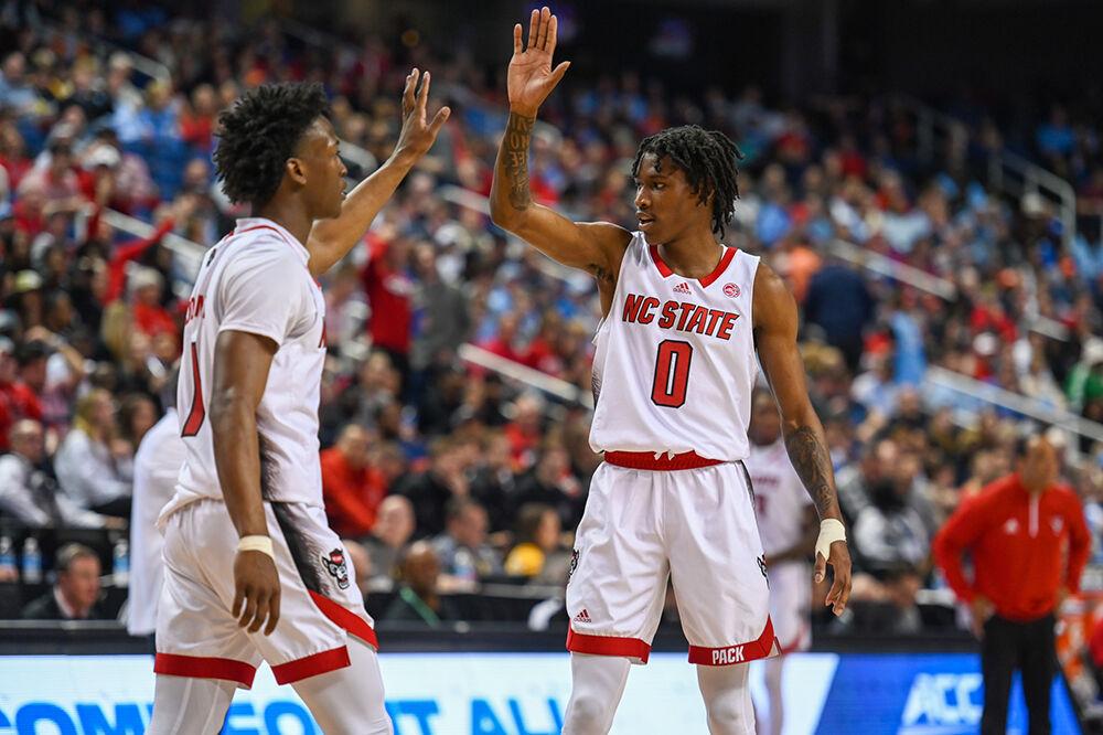 Graduate guard Jarkel Joiner (left) and sophomore guard Terquavion Smith (right) high-five during the second round of the ACC Tournament against Virginia Tech in Greensboro Coliseum on Wednesday, March 8, 2023. NC State won the game against Virginia Tech 97-77.