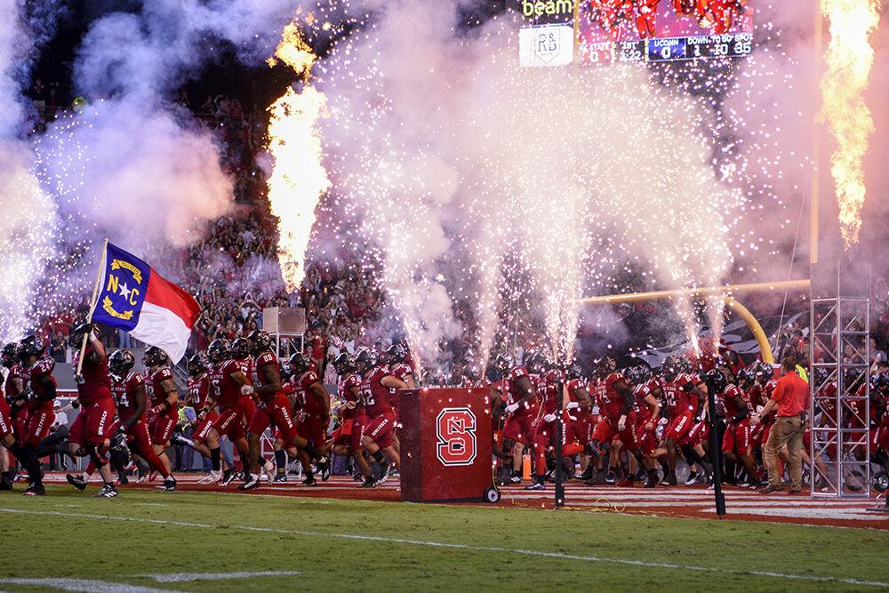 The Wolfpack football team runs onto the field before the game against UConn in Carter-Finley Stadium on Saturday, Sept. 24, 2022. The Wolfpack beat the Huskies 41-10.