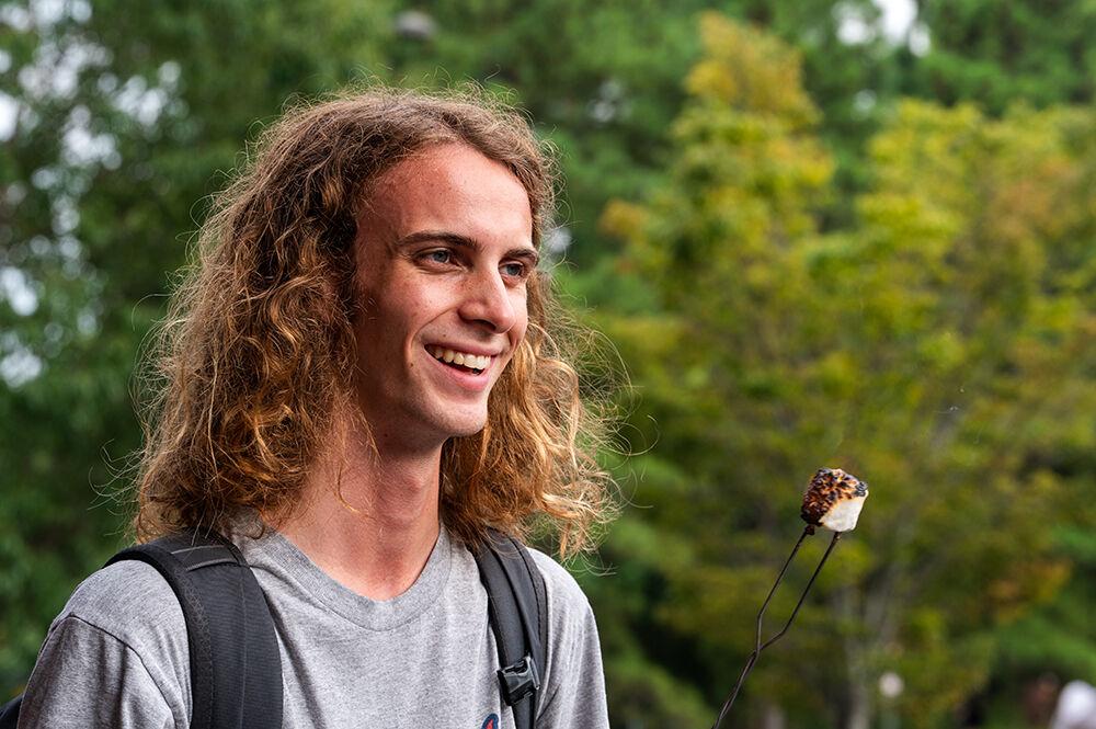 Jack Fulp, a first-year studying environmental technology and management, roasts a marshmallow during the S'mores by the Campfire event outside Carmichael Gym on Tuesday, Aug. 22, 2023. This event was hosted by Outdoor Adventures as a part of Wolfpack Welcome Week.